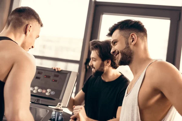 Deportistas guapos ajuste cinta de correr en el gimnasio - foto de stock