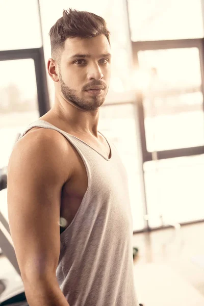 Portrait de beau sportif regardant la caméra dans la salle de gym — Photo de stock