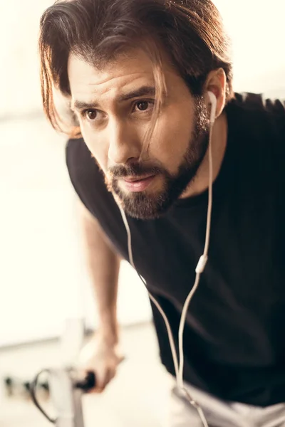 Vista da vicino del giovane sportivo barbuto che si allena e distoglie lo sguardo in palestra — Foto stock