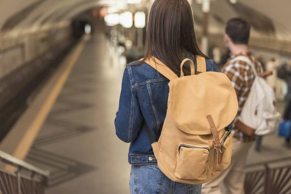 Visão traseira de turistas com mochilas descendo na estação de metrô — Fotografia de Stock