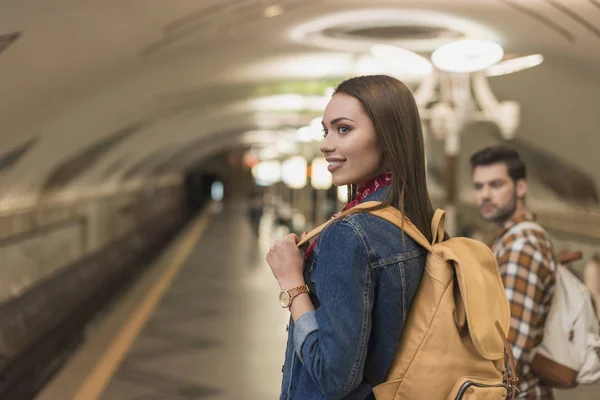 Sorridente jovem viajante feminino com namorado na estação de metrô — Fotografia de Stock