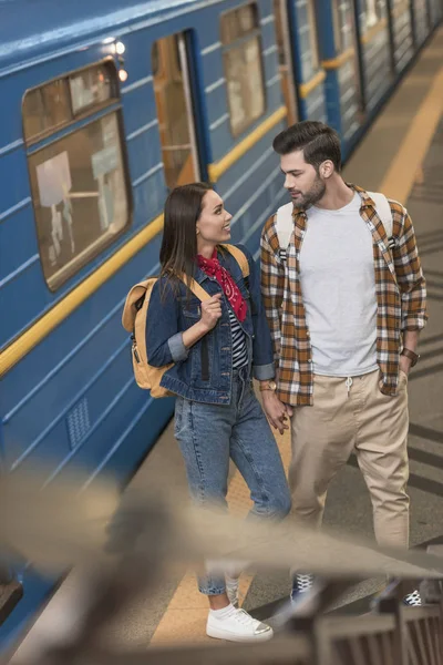 Viajeros con estilo con mochilas en la estación de metro - foto de stock