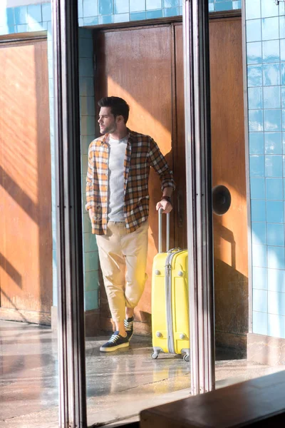 Stylish male tourist with wheeled bag at subway station — Stock Photo