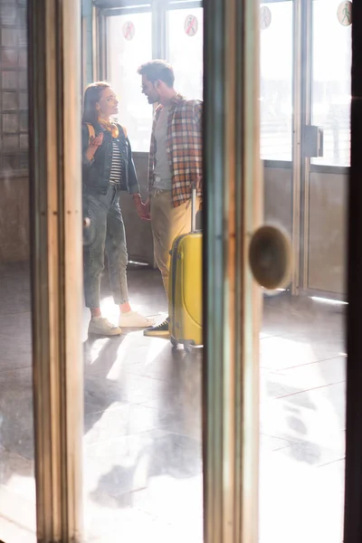 Stylish couple of tourists with backpack and wheeled bag at subway — Stock Photo