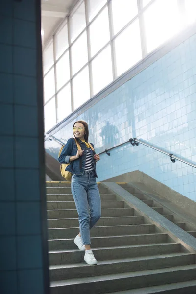 Jovem turista elegante em óculos de sol com mochila descendo no metrô — Fotografia de Stock