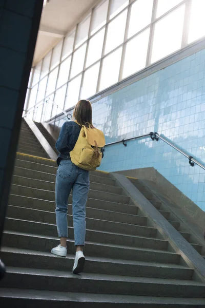Visão traseira de turista feminino com mochila indo para cima no metrô — Fotografia de Stock