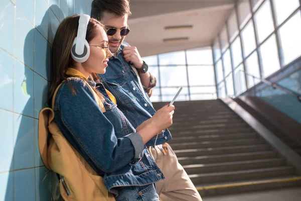 Stilvolles Touristenpaar blickt auf Smartphone-Bildschirm in U-Bahn — Stockfoto