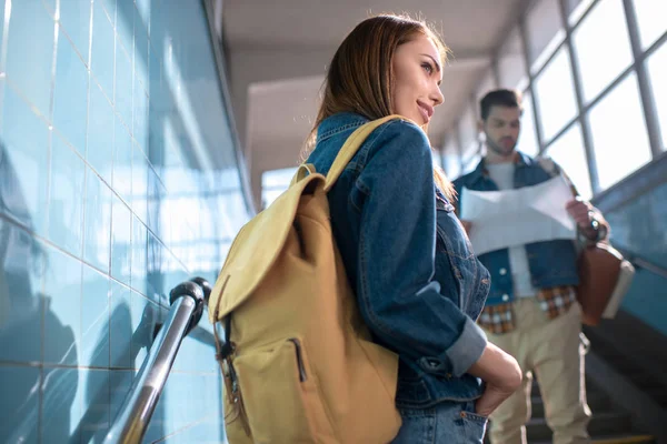 Sonriente mujer elegante turista y novio mirando el mapa detrás - foto de stock