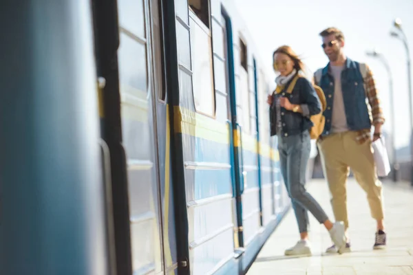 Stylish couple of travelers waiting to come into train at outdoor subway station — Stock Photo