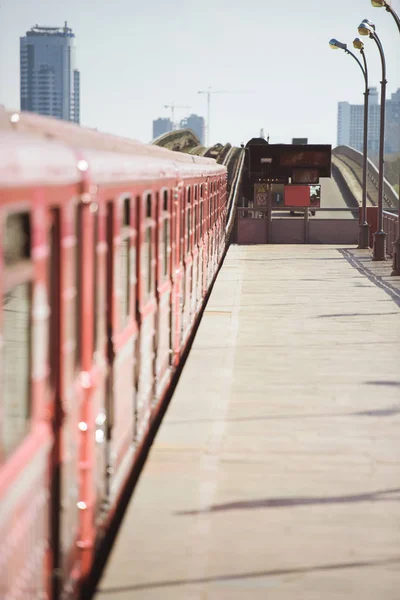 Trem na estação de metrô ao ar livre com edifícios no fundo — Fotografia de Stock