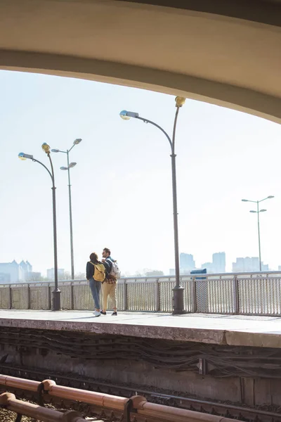 Vista lejana de la elegante pareja de turistas que van en la estación de metro al aire libre - foto de stock