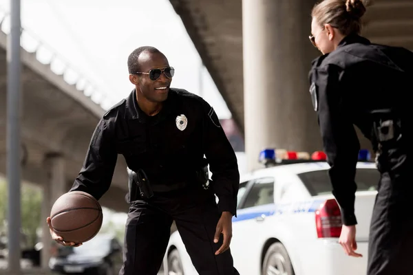 Giovani agenti di polizia che giocano a basket vicino all'auto — Foto stock