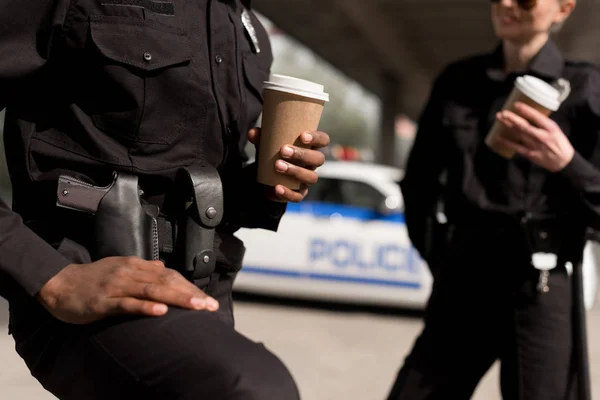 Recortado disparo de los agentes de policía teniendo pausa para el café - foto de stock