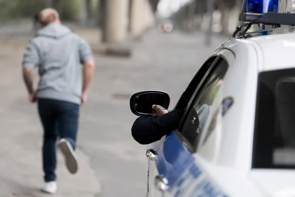 Coup de feu recadré de policier sur voiture chassant voleur — Photo de stock