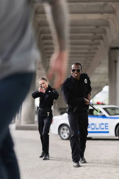 Tiro cortado de ladrão que foge de policiais multiétnicos — Fotografia de Stock