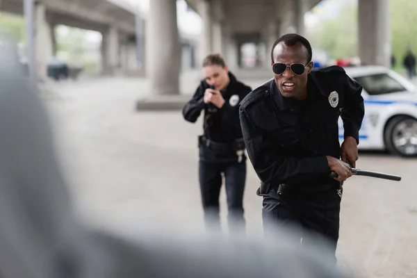 Multiethnic police officers running for thief — Stock Photo