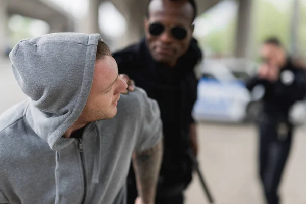 Close-up shot of african american police officer catching thief — Stock Photo