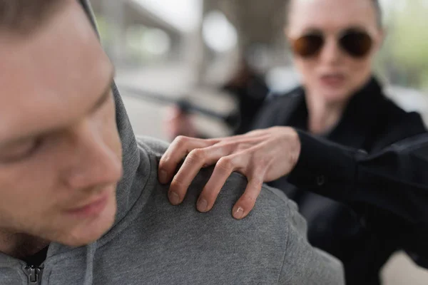 Close-up shot of policewoman catching shoulder of thief — Stock Photo