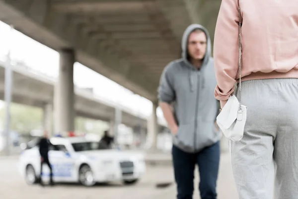 Cropped shot of woman with handbag and thief in hoodie — Stock Photo