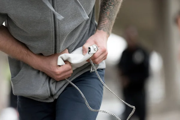 Plan recadré de voleur avec main tatouée courant avec sac à main volé — Photo de stock