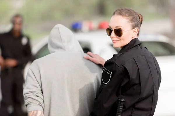 Policial sorridente em óculos de sol com criminoso preso — Fotografia de Stock