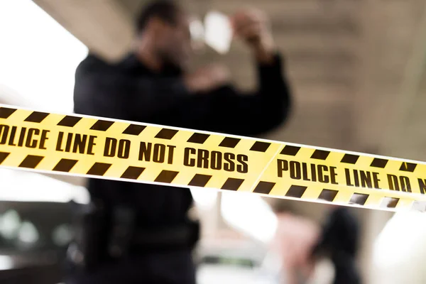 Close up view of cross line and policeman standing behind on blurred background — Stock Photo