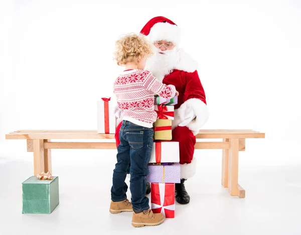 Santa Claus con niño y cajas de regalo — Foto de stock gratis