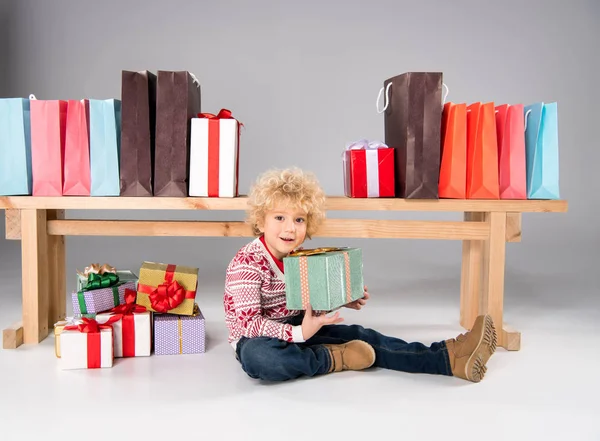 Kid met geschenkdozen en draagtassen — Stockfoto