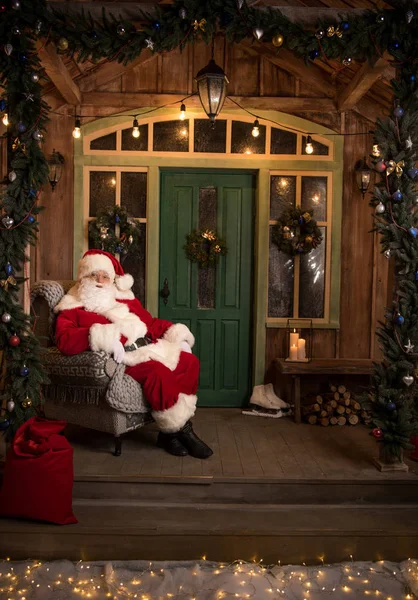 Happy Santa Claus sitting in armchair — Stock Photo, Image