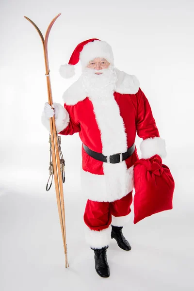 Santa Claus caminando con sacos y esquís de madera — Foto de Stock