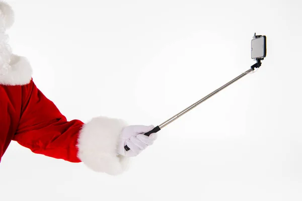 Weihnachtsmann Hand zeigt Selfiestick — Stockfoto