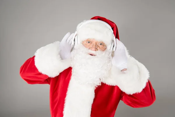 Santa Claus escuchando música con auriculares —  Fotos de Stock