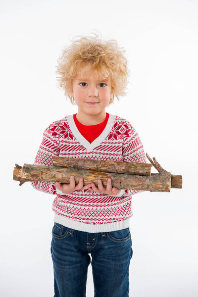 ребенок стоит с дровами в руках
