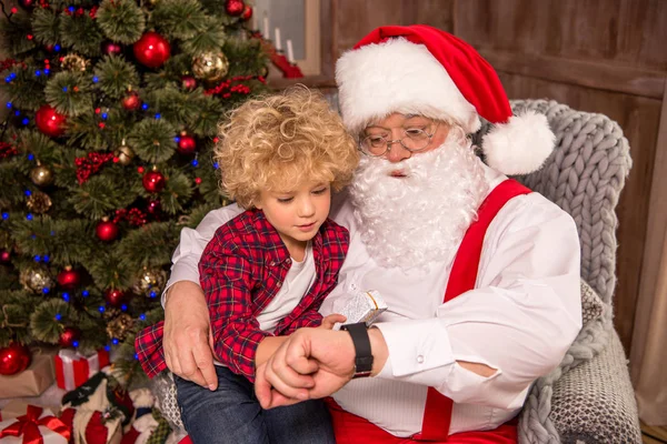 Санта-Клаус с ребенком на коленях — стоковое фото