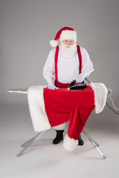Santa Claus σιδερώματος παλτό — Φωτογραφία Αρχείου