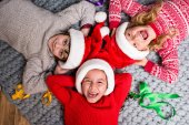 Kinder mit Weihnachtsmützen liegen im Kreis