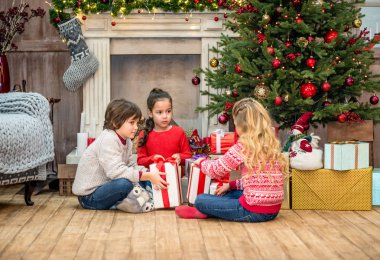 Noel hediyeleri ile katta oturan çocuklar