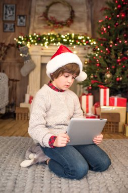Noel Baba şapkası dijital tablet kullanarak çocuk
