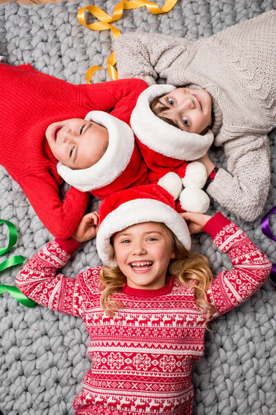 дети в шляпах Санта лежит в кругу
