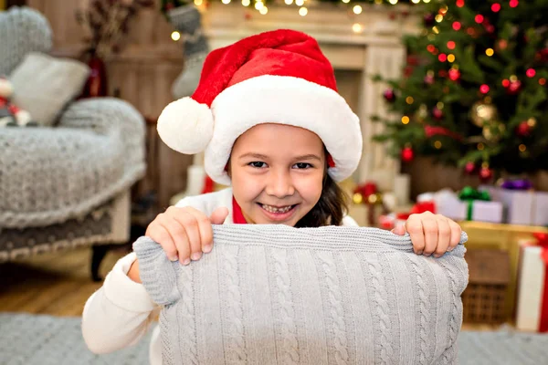 Kid in Santa hat holding pillow — Free Stock Photo