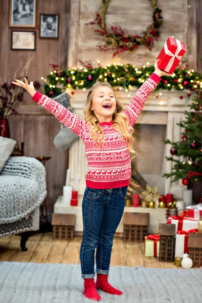 Kid rising arms up with gift box — Stock Photo, Image