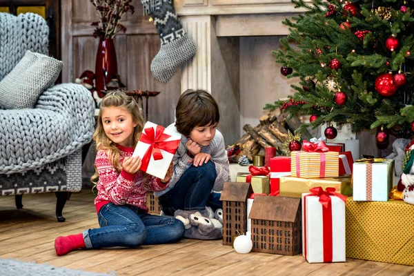 Niños sentados cerca de cajas de regalo — Foto de Stock