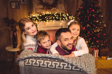 kameraya gülümseyen mutlu bir aile