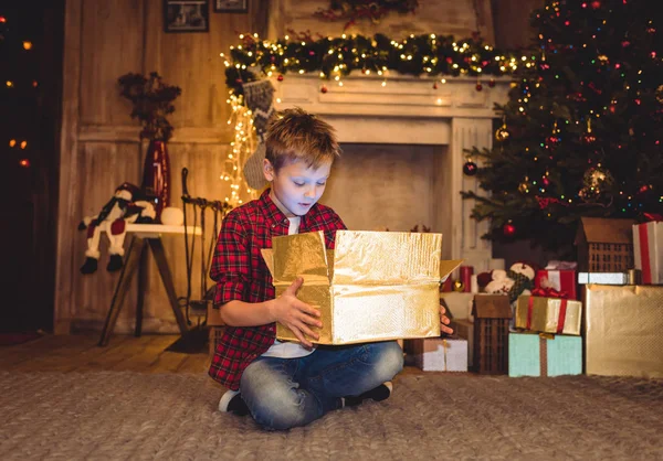 Junge öffnet Weihnachtsgeschenk — Stockfoto