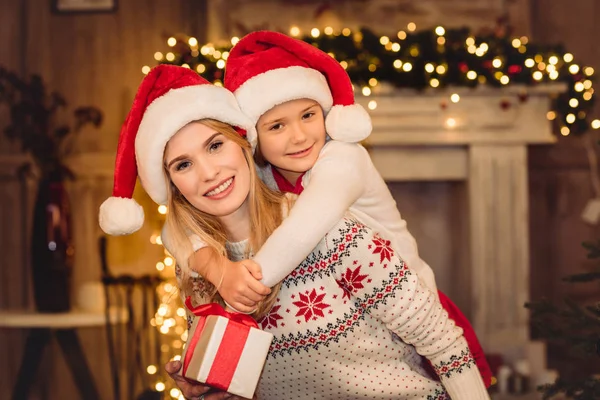 Happy mother and daughter in santa hats — Stock Photo, Image