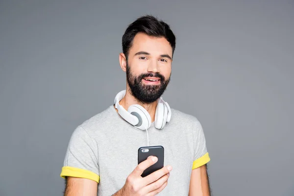 Бородатий чоловік використовує смартфон — стокове фото