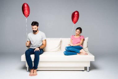 Kırmızı balonlar ile kanepede oturan Çift