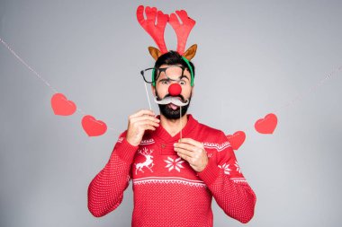 Man in antlers holding party sticks clipart