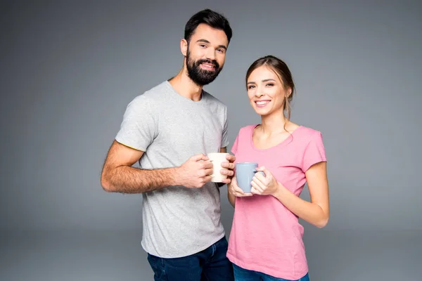 Couple holding cups — Stock Photo, Image