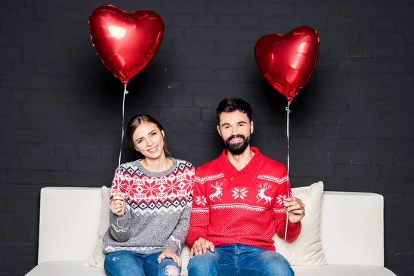 Pareja con globos corazones rojos —  Fotos de Stock